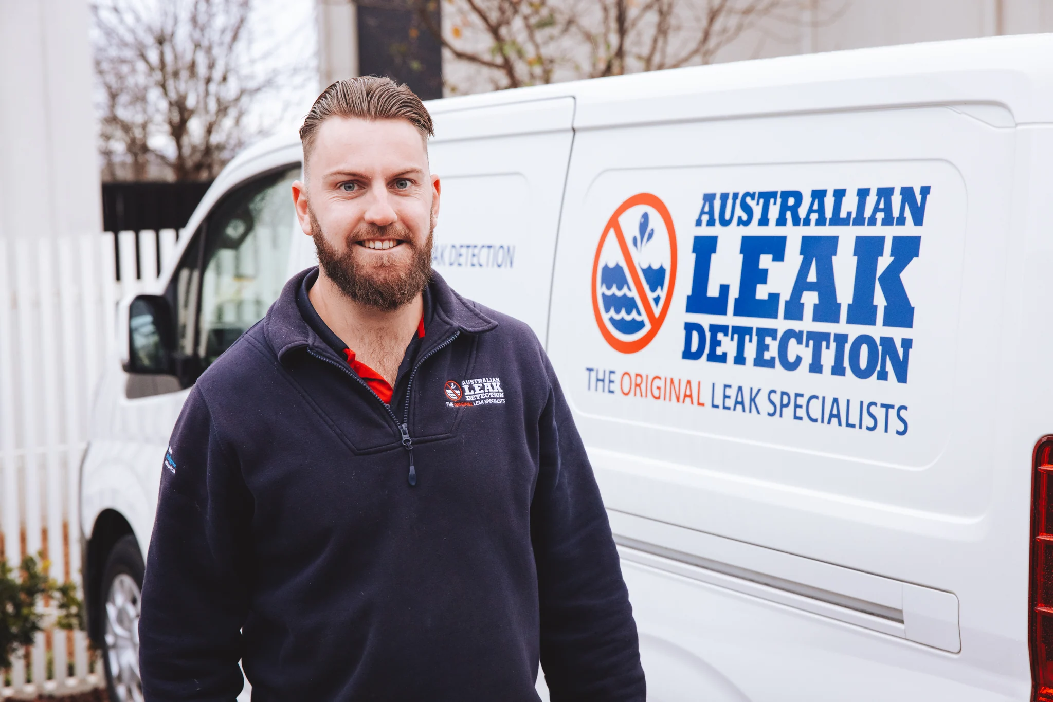 ALD specialist beside an Australian Leak Detection service vehicle