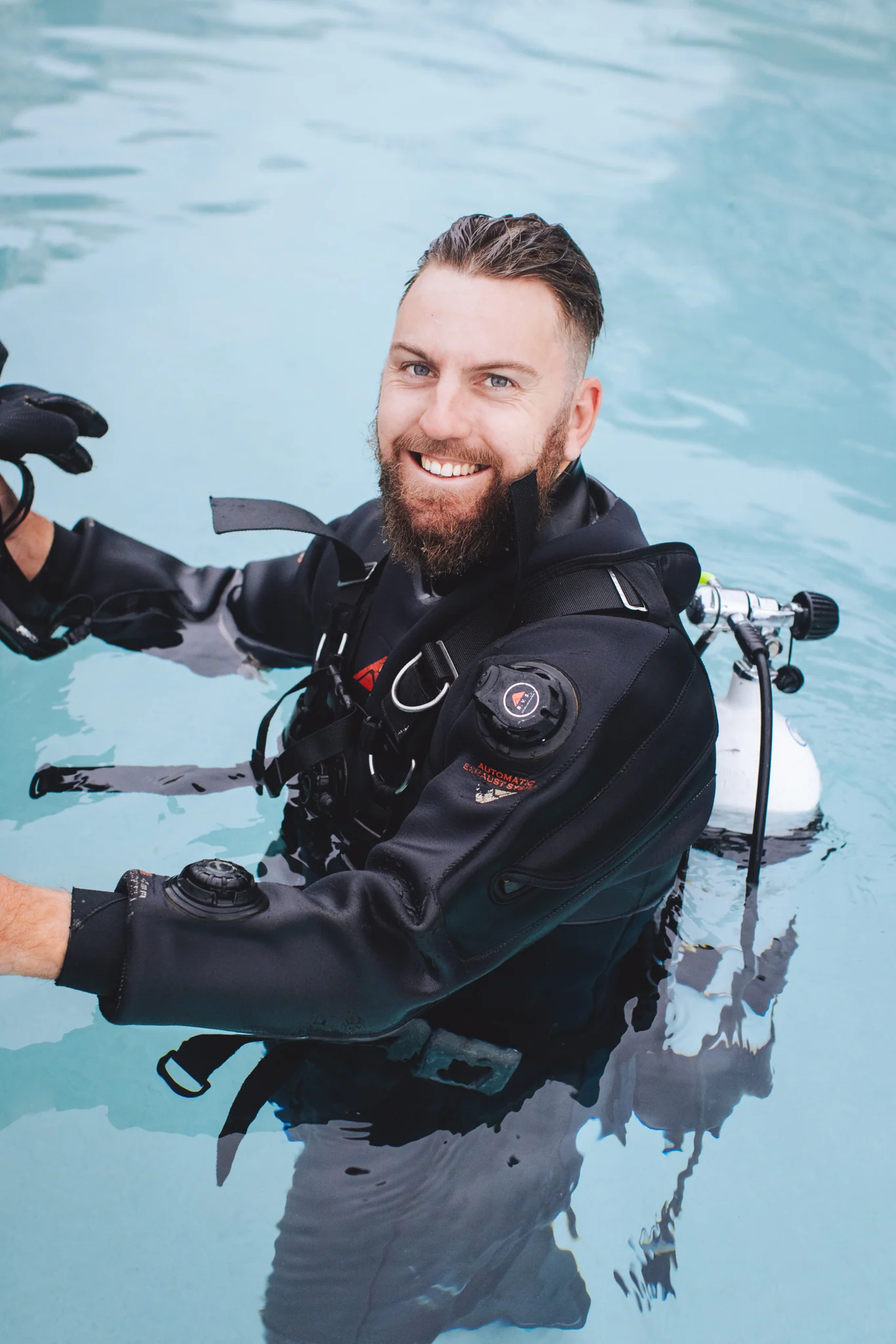 Pool leak detection diver inspecting a swimming pool with specialist equipment
