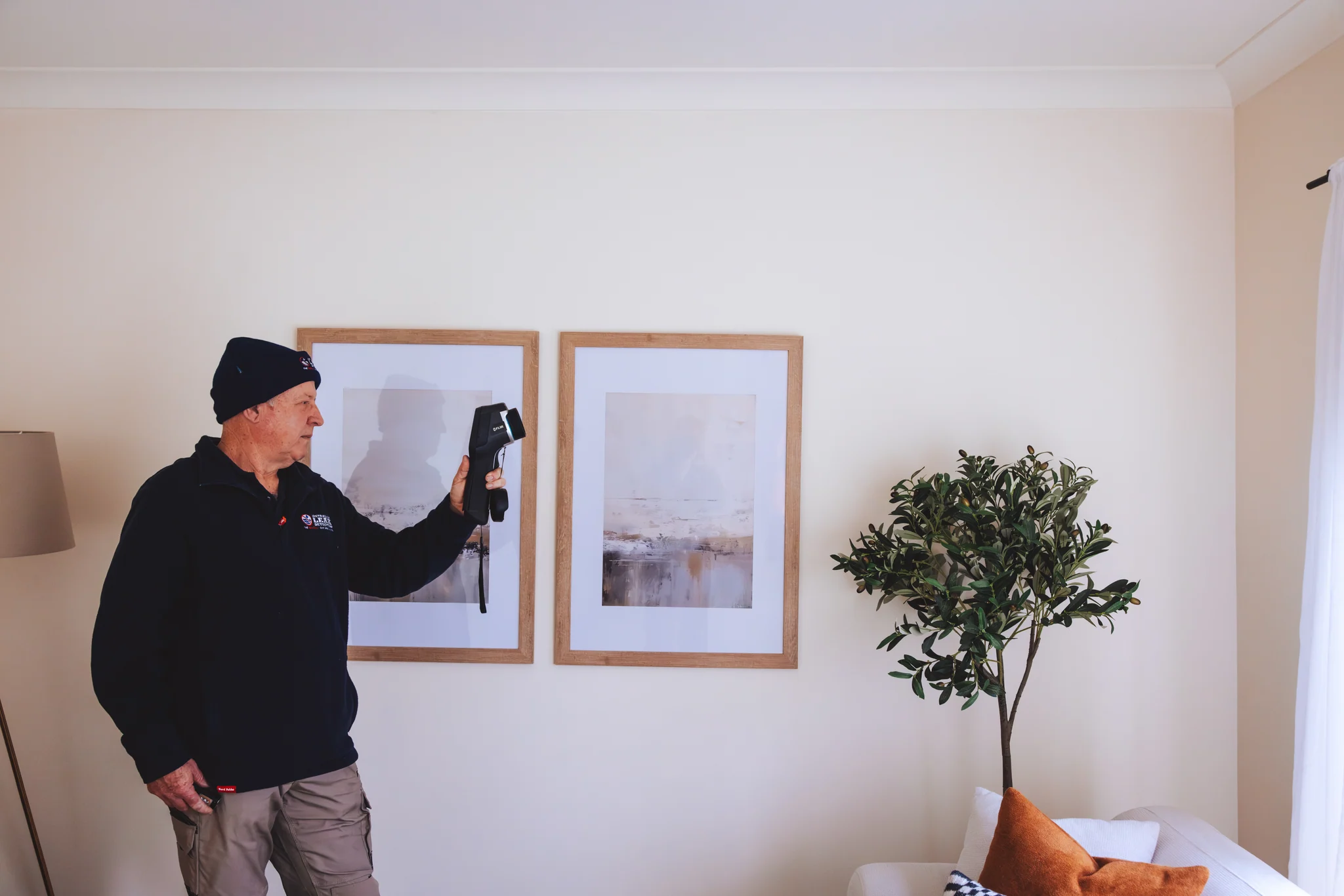 ALD technician scanning a home with a thermal imaging camera
