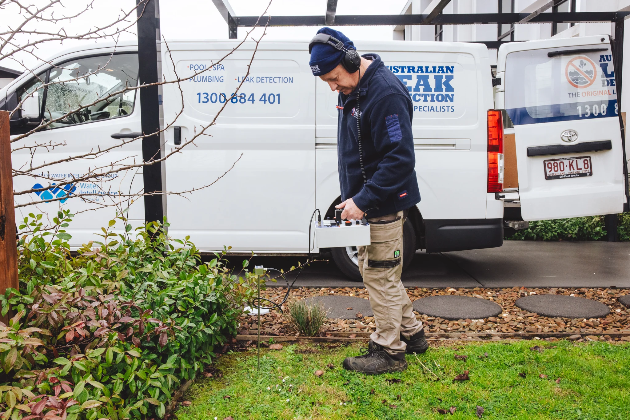 ALD specialist carrying acoustic leak detection equipment beside a service vehicle