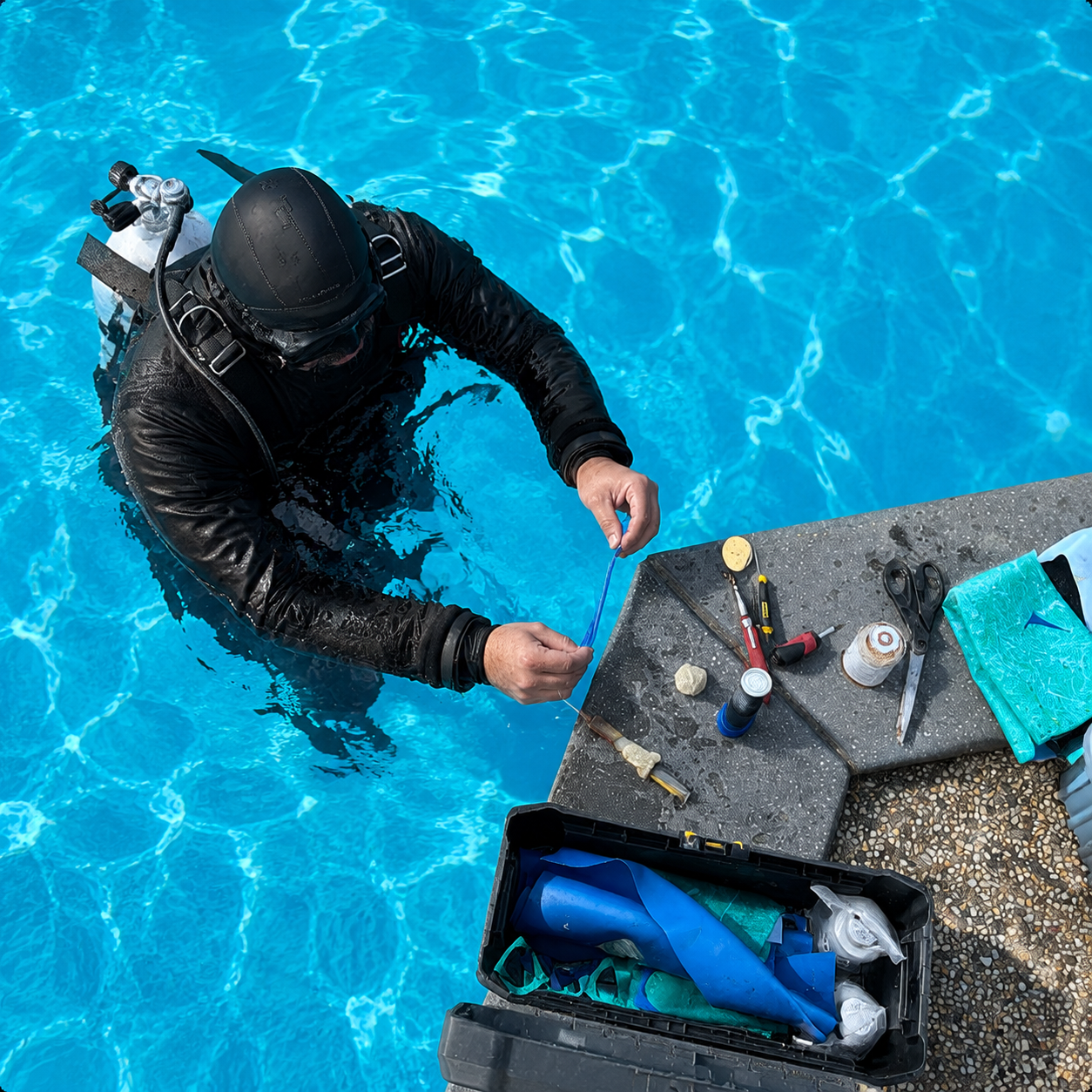 Pool leak detection diver inspecting a swimming pool with specialist equipment