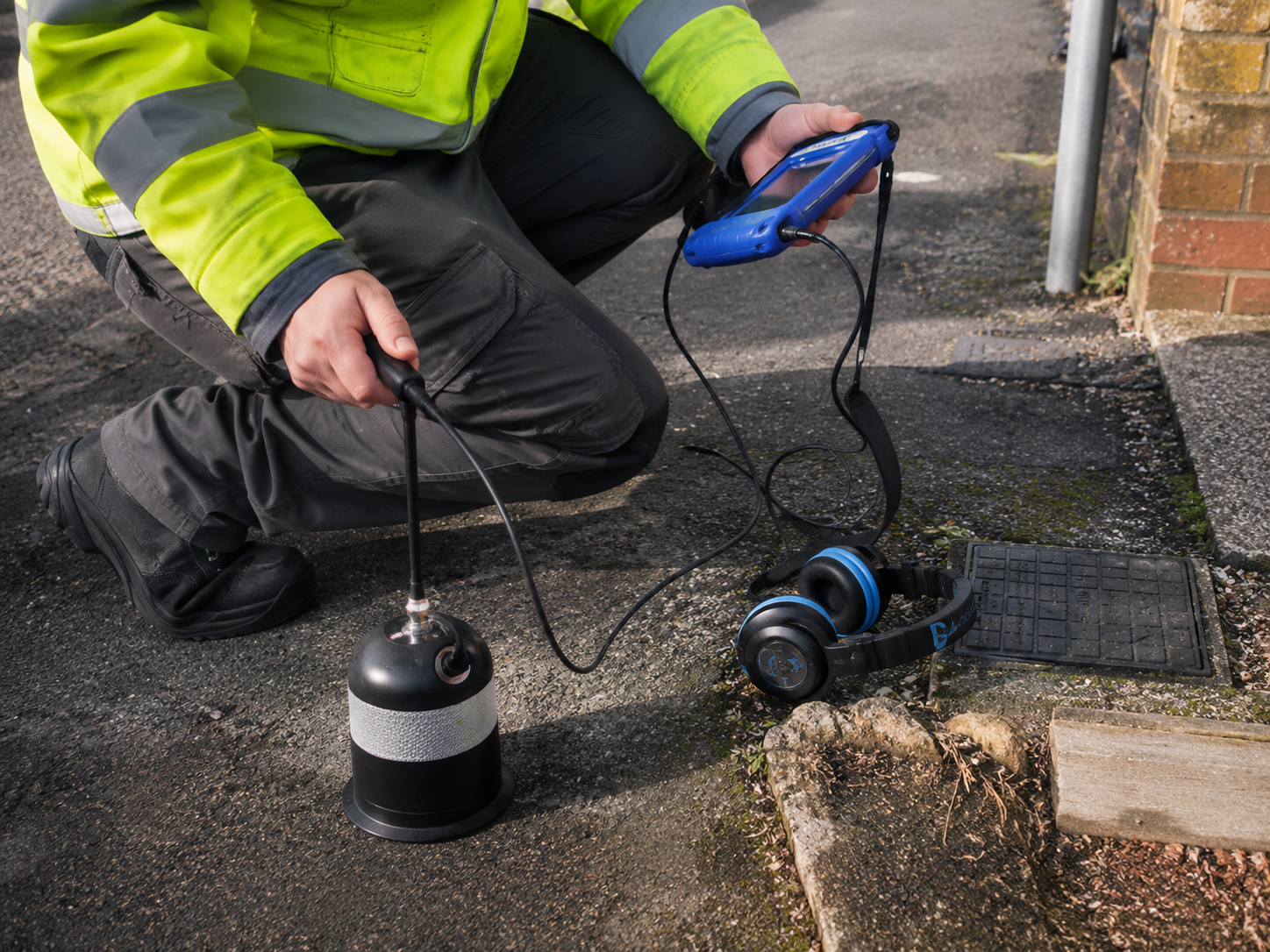 Acoustic leak detection technician in Australia using specialist listening equipment to locate an underground water leak